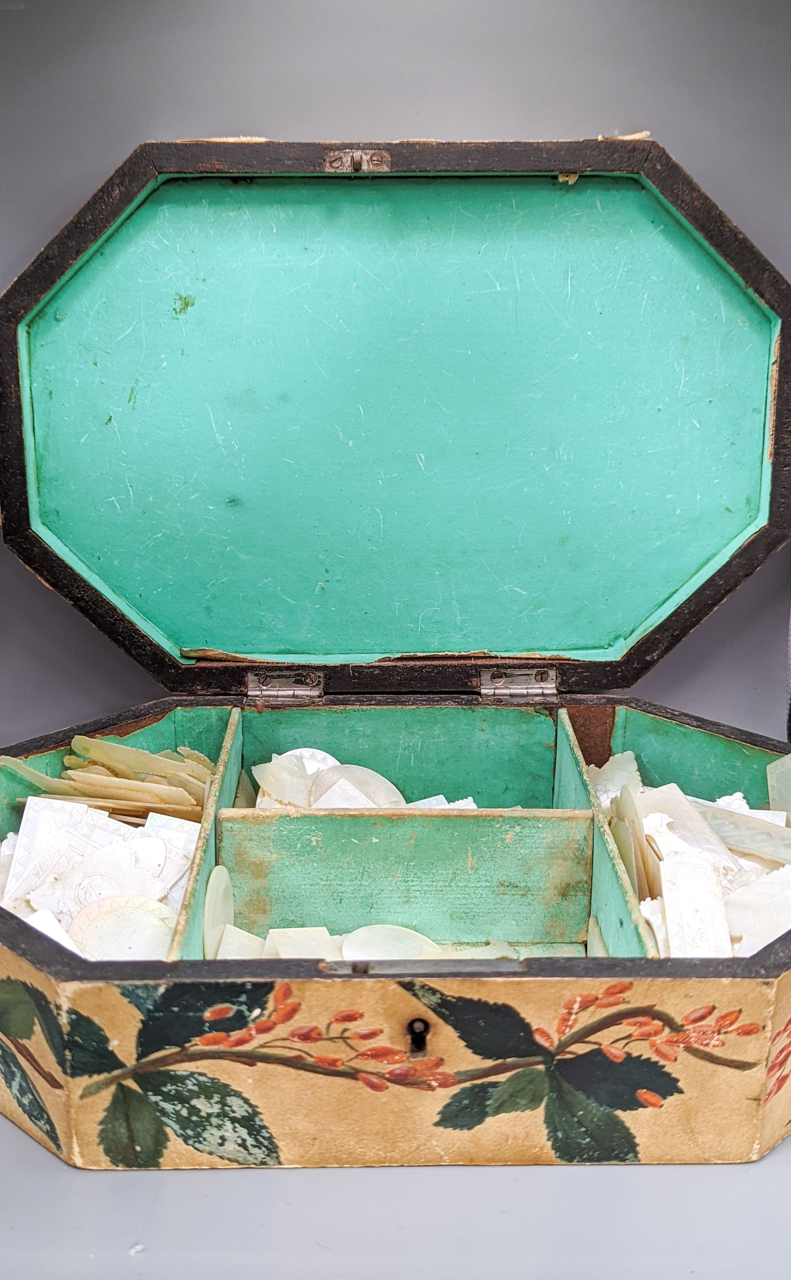 A collection of 19th century Cantonese etched mother of pearl gaming counters, within a lidded octagonal box, 26cm